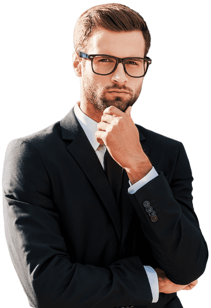 Young man in a black suit and glasses, posing thoughtfully with his hand on his chin and arms crossed.